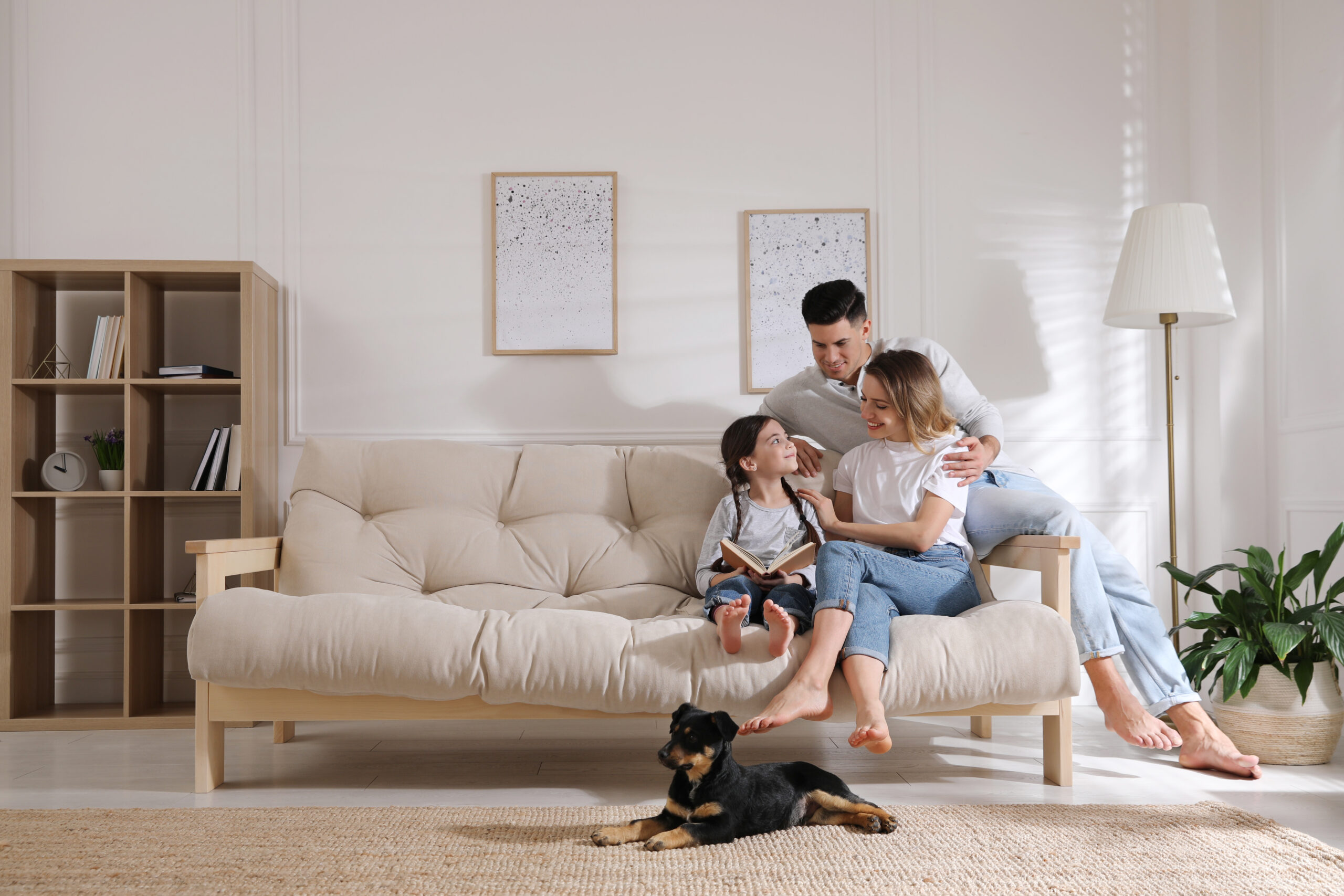 Family of 3 and pet dog sitting on a couch
